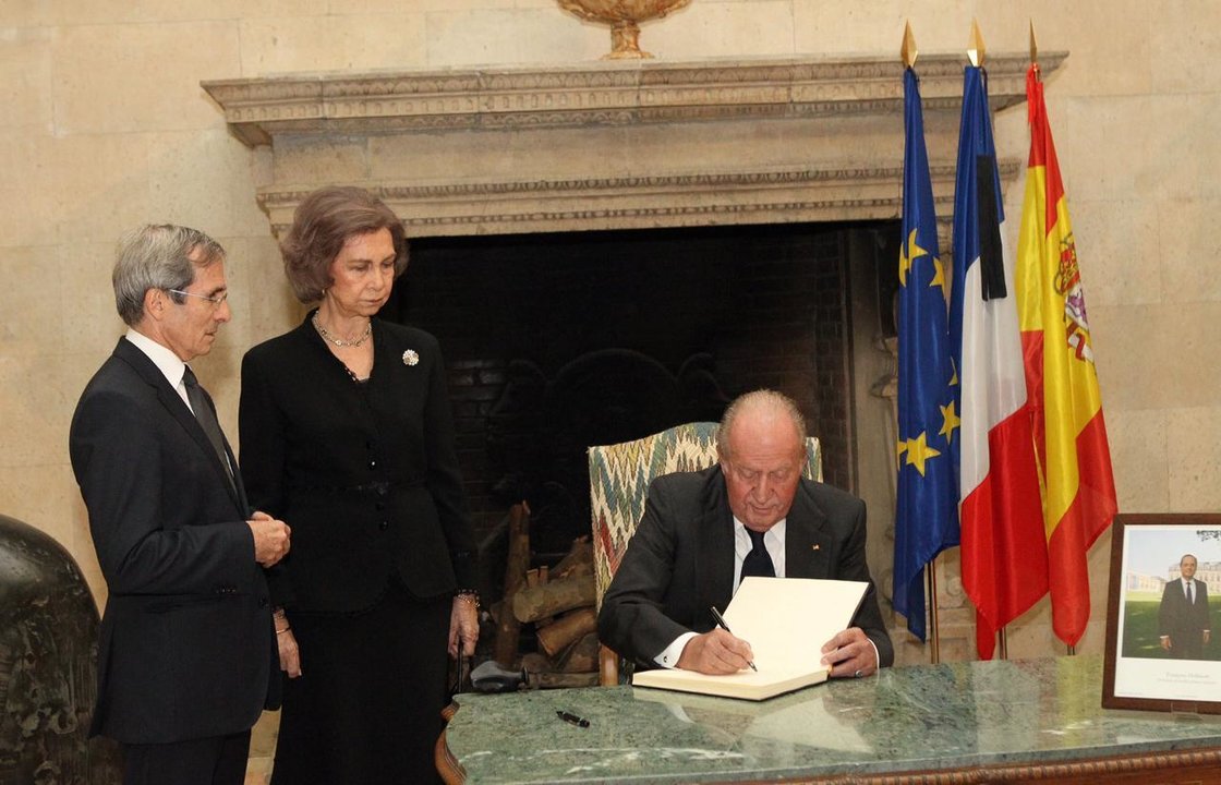 Los reyes Juan Carlos y Sofía firman en el libro de condolencias de la Embajada de Francia en España.