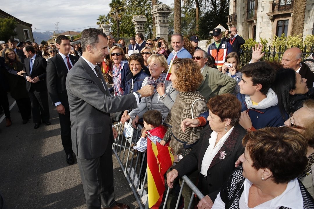 Felipe VI saluda a ciudadanos ante la vigilancia de un miembro de la escolta.