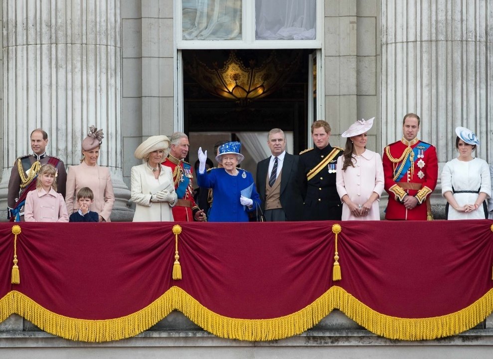 La reina Isabel saluda en el Palacio de Buckingham rodeada por su familia.