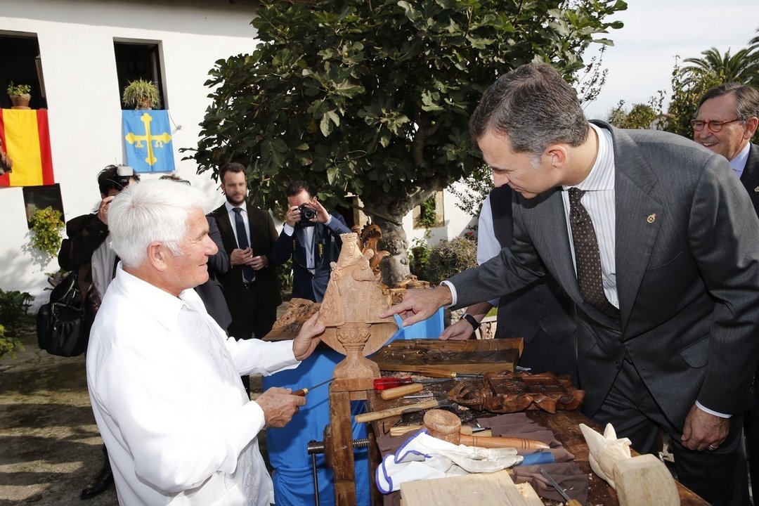 El rey observa la labor de un artesano en Colombres, Pueblo Ejemplar de Asturias 2015.