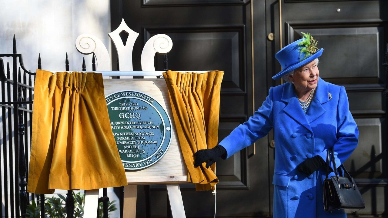 La reina Isabel II descubre la placa del centenario del GCHQ en su sede.