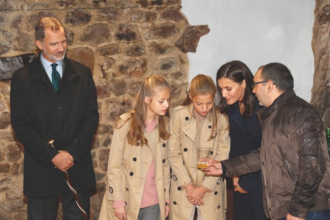 Los Reyes junto a la Princesa de Asturias y la Infanta Sofía observan como se elabora de forma artesanal la sidra