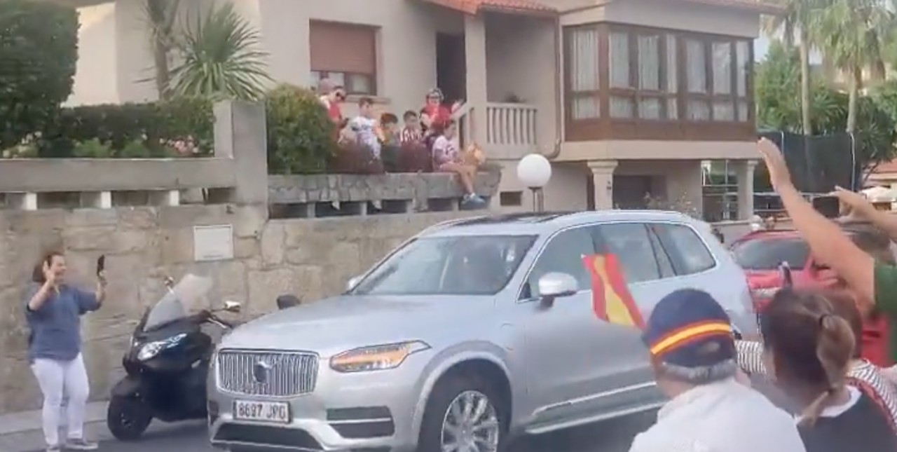 Pedro Campos llega conduciendo su coche, mientras varios vigueses gritan "viva el rey".