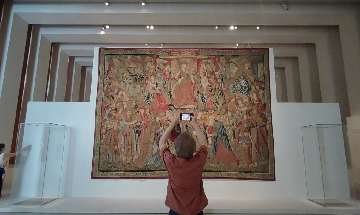 Visitante sacando foto de un tapiz en l a Galería de las Colecciones Reales