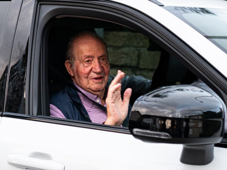 El rey Juan Carlos saluda a su salida en coche de casa de Pedro Campos hacia el aeropuerto de Vigo