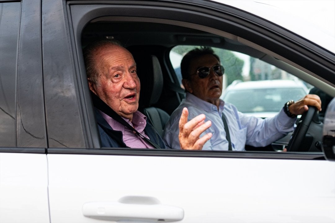 El rey Juan Carlos (i) saluda a su salida en coche de casa de Pedro Campos hacia el aeropuerto de Vigo. Foto de archivo.