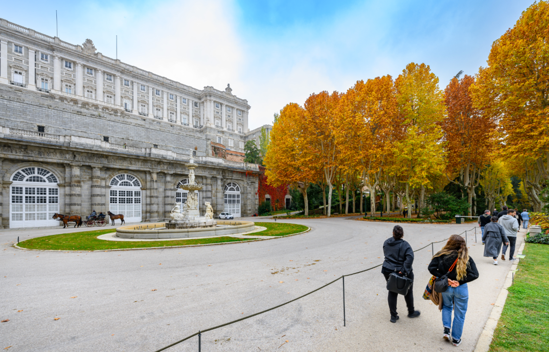 Visitantes admiran la fachada del Palacio Real y la Fuente de los Tritones