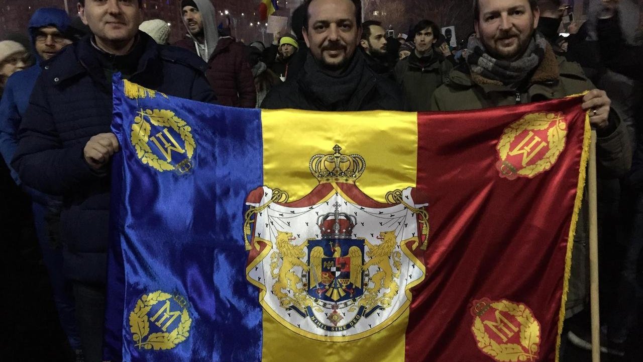 Manifestantes en Rumanía con una bandera monárquica.