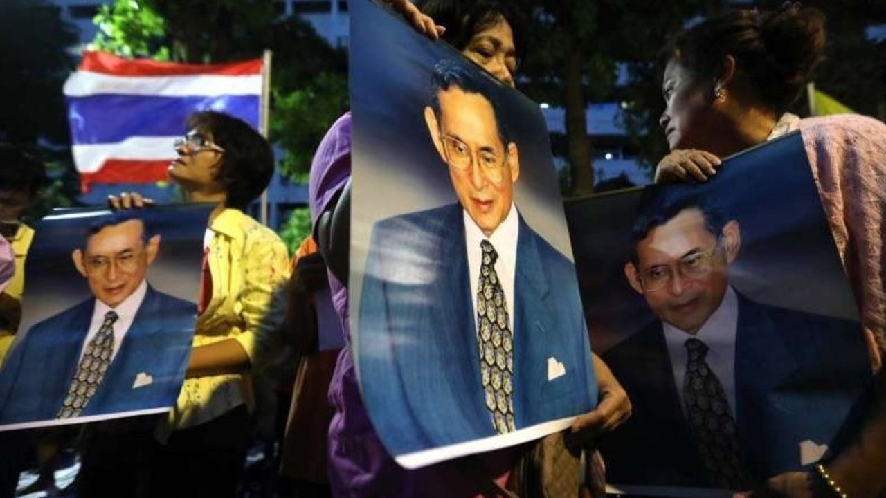 Tailandeses exhiben retratos del fallecido rey Bhumibol.
