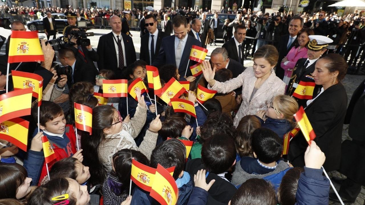Los reyes saludan a un grupo de niños en Oporto.